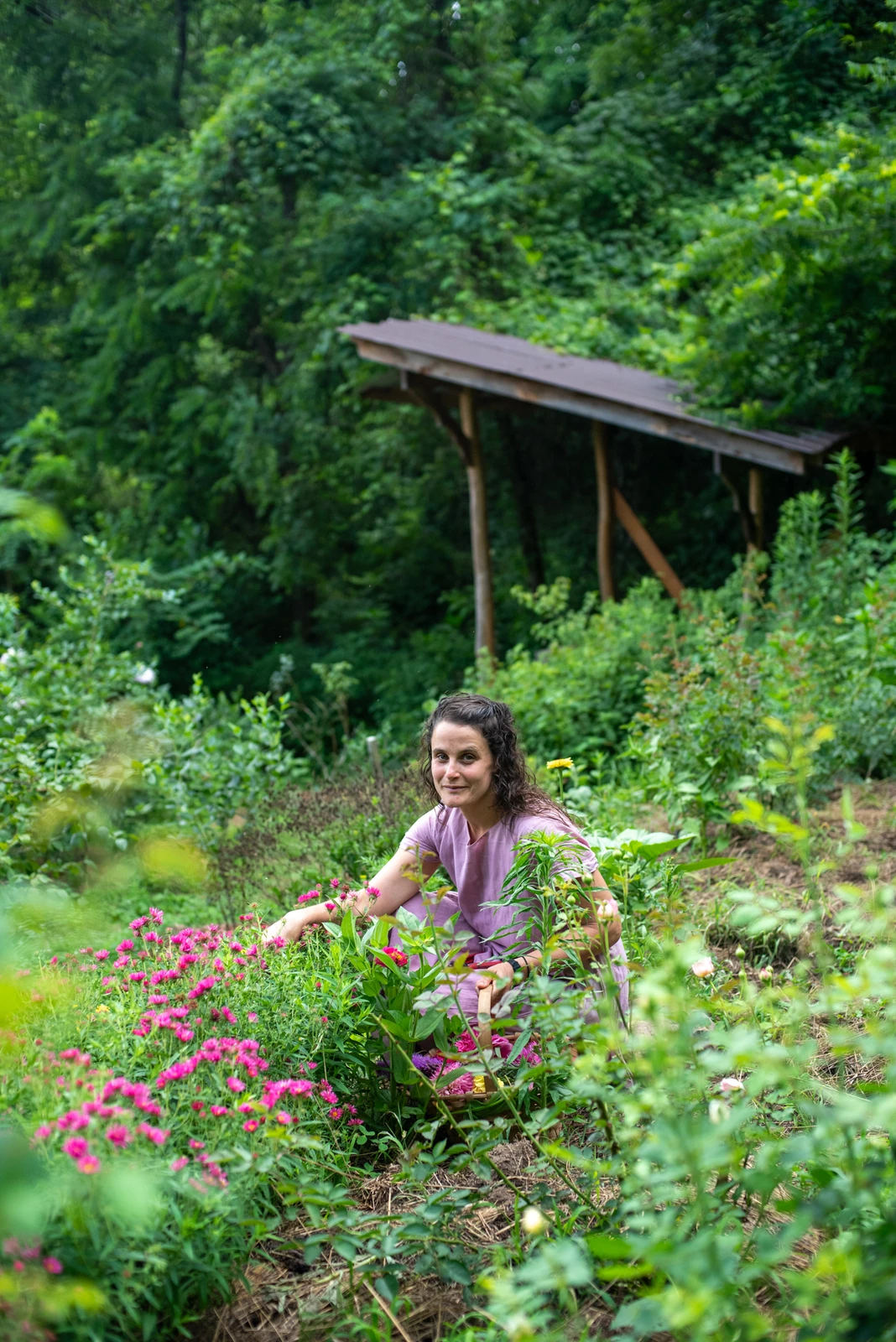 Steph gathering flowers in a lush garden